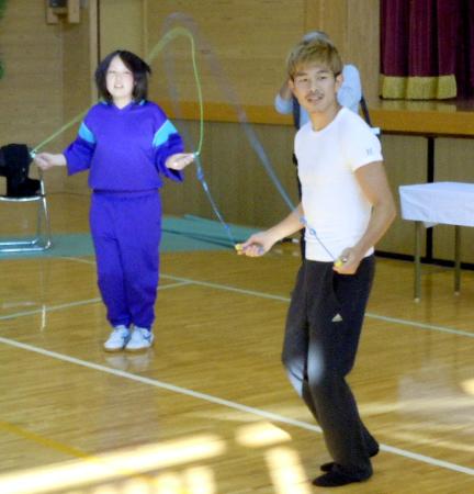 　生徒に縄跳びの指導をする井岡一翔（右）