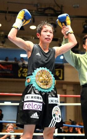 チャンピオンベルトを巻いてガッツポーズの小関桃（撮影・金田祐二）