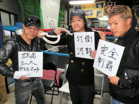 ペットのヘビと今年の目標を書き込んだ色紙を手にする亀田３兄弟の（左から）興毅、大毅、和毅＝東京都葛飾区の亀田ジム