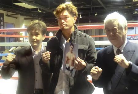 　対戦相手ゴロフキンの写真を手にガッツポーズを取る石田。左は本石マネジャー、右は小松後援会長
