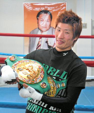 赤ちゃんを抱くようにベルトを手にする佐藤洋太