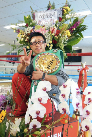 お祝いの花に囲まれてＶサインを決める八重樫東＝横浜市内の大橋ジム