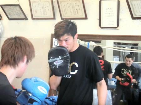 ミットを持ってパンチを受ける石田