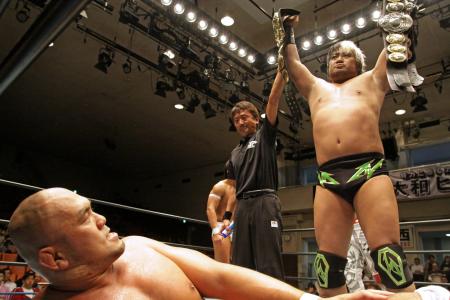 　秋山準から３カウント奪い、高々と三冠のベルトを掲げる諏訪魔