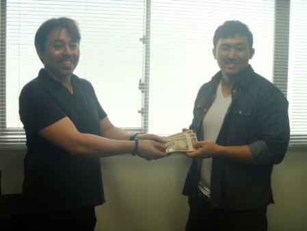 　サイモン・ケリー莉あ猪締役から渡された優勝賞金３００万円を確認する鈴木秀樹（左）