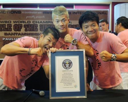 　ギネス認定証とともにポーズをとる亀田３兄弟。左から長男興毅、三男和毅、次男大毅＝２日、フィリピン・セブ（共同）