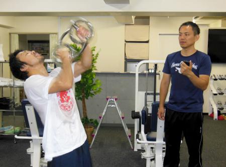 　「バーンマシン」という器具でトレーニングを行う八重樫東（左）と土居進氏　