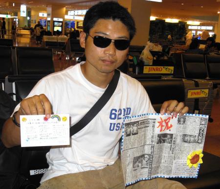 　客室乗務員から贈られた新聞の切り抜きを手にする三浦隆司