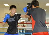 　父・真吾さん（奥）が見つめる中、弟の拓真さん（右）とマスボクシングをする井上尚弥