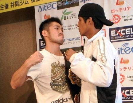 　調印式でにらみ合いをする宮崎（左）とシルベストレ＝ホテルモントレグラスミア