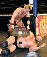 アンダーソン（下）にいす攻撃を食らわせるオカダ・カズチカ（撮影・岡田育磨）