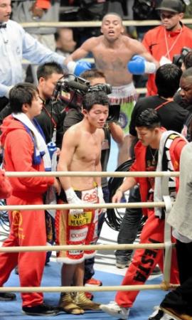 【ＩＢＦ・ＷＢＡ世界Ｓフライ級王座統一戦】判定負けを喫しリングにぼうぜんと立ち尽くす亀田大毅。後方は小躍りして喜ぶソリス（１２月３日、ボディメーカーコロシアム）