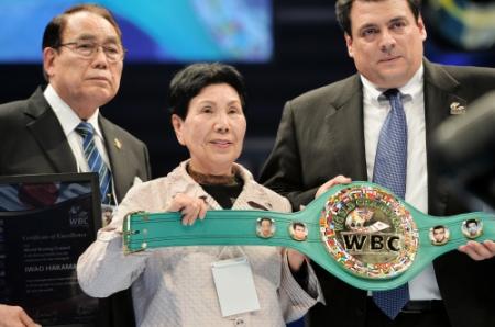 現役時代（右端）と現在（左端）の巌さんの写真が入ったベルトを手にする姉の袴田ひで子さん（中央）＝撮影・佐々木彰尚