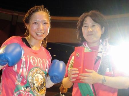 　世界王座を奪取し、リング上で母（右）にベルトを贈った黒木