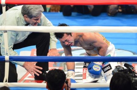 ７回、ペドロ・ゲバラのパンチをボディーに受け顔をゆがめる八重樫東＝東京体育館（撮影・村中拓久）