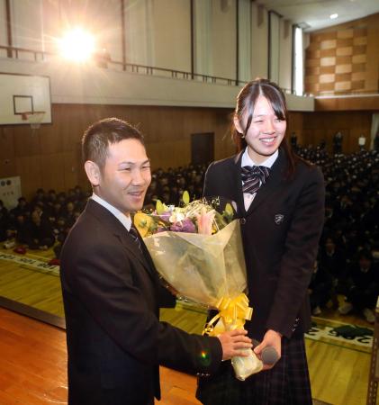 　ボクシング４団体制覇の報告会で生徒会長の望月梨瑚さん（右）から花束を受ける高山勝成