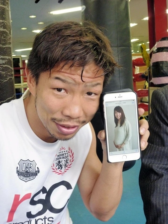 　妊娠８カ月の香夫人の携帯フォトを手に必勝を誓う細川