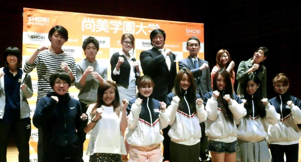 　学生とガッツポーズを取る高野（後列左から４人目）と右隣の小橋