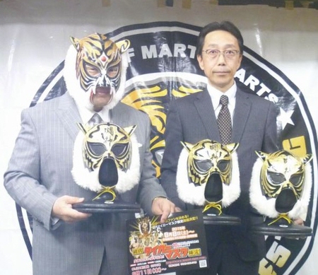 初代タイガーマスク検定の優勝者に贈られるマスクを持つ初代タイガーマスク（左。右は検定を手がけるサーティファイ企画室の及川洋司氏）