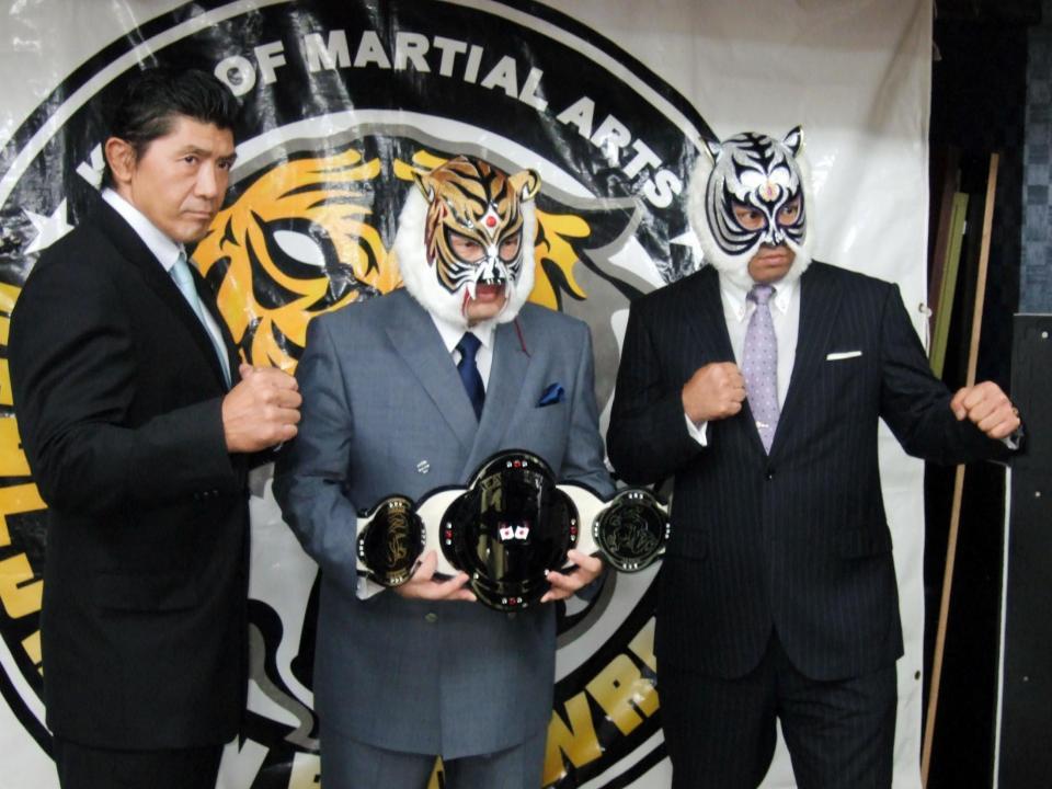 　レジェンド選手権を争う王者スーパー・タイガー（右）と船木誠勝（左）。中央は初代タイガーマスク＝東京・文京区の興義館