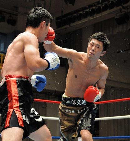 　６回、秋山泰幸（左）に右を打ち込む柴田明雄（撮影・田村亮介）