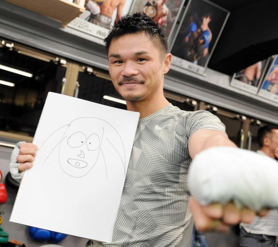 　直筆の芽衣夫人の似顔絵を手にポーズを決める河野公平（撮影・開出牧）