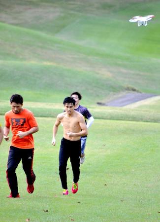 　ドローン（右上）に密着マークされながらゴルフ場のコースを駆け上がる一翔ら