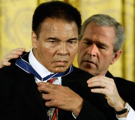 　２００５年11月、ワシントンのホワイトハウスで、ブッシュ米大統領（後方）から「大統領自由勲章」を授与されるムハマド・アリ氏（ロイター＝共同）