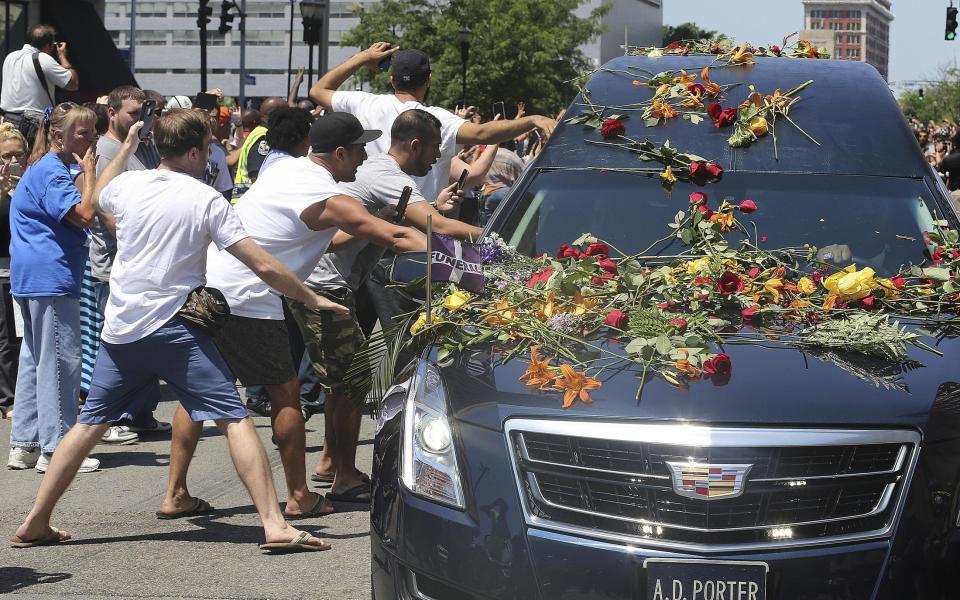 　ムハマド・アリ氏の遺体を乗せた霊きゅう車に触れようと手を伸ばす人々