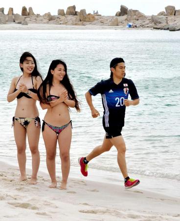 　ビキニ美女も熱視線！サッカー日本代表・槙野のユニホームを着て白良浜を走る井岡一翔（右）