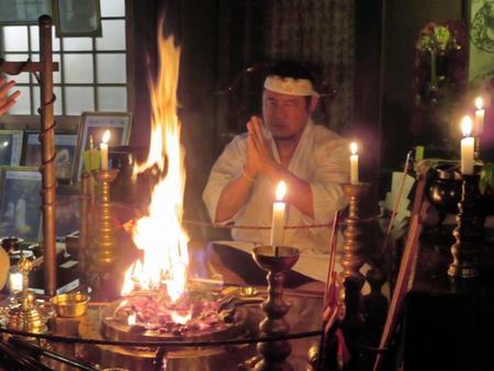 炎に向かって祈りを捧げる永田＝埼玉県和光市内の清龍寺