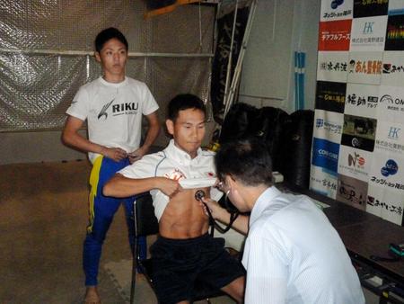 加納陸（左）が見る前で検診を受ける高山勝成