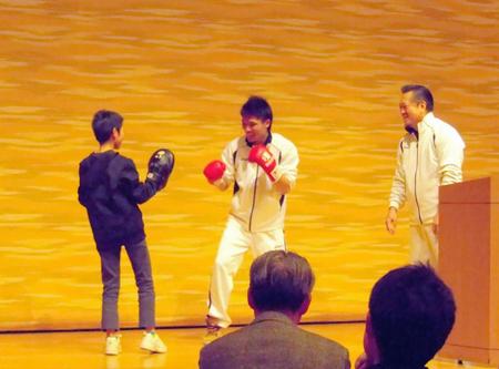 子どもあを相手にミット打ちをする久保（中央、右は山下会長）