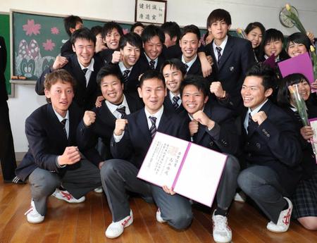 　卒業証書を手にクラスメートと記念写真に納まる高山勝成（前列中央）