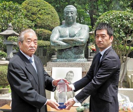 　記念トロフィーを贈呈される百田光雄（左）