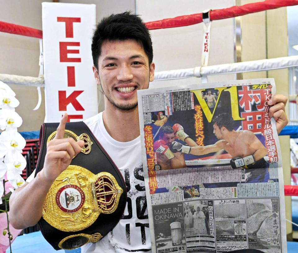 　見事な初防衛戦勝利を報じるデイリースポーツを手に笑顔ををみせる村田諒太