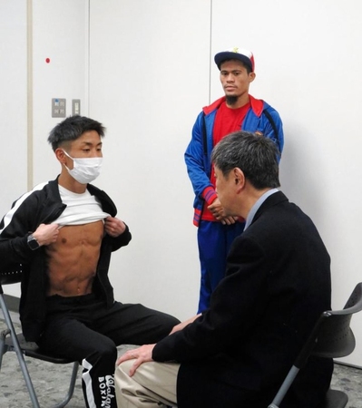 検診を受ける谷口（左）と、それを見つめるサルダール＝東京都文京区の後楽園ホール展示会場