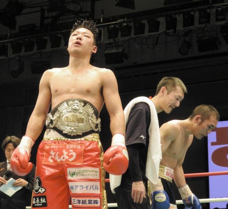 引き分けで王座を防衛し、リング上で立ち尽くす竹迫（中央）と観衆に頭を下げる加藤（右）＝東京都文京区の後楽園ホール