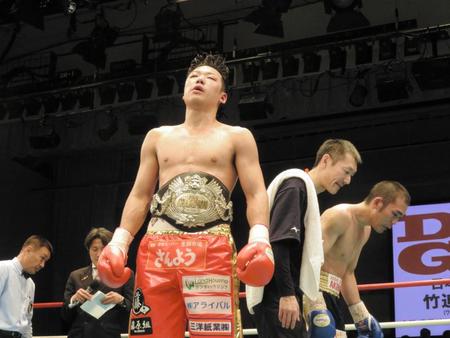 引き分けで王座を防衛し、リング上で立ち尽くす竹迫（中央）と観衆に頭を下げる加藤（右）