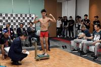 前日計量を一発でパスし、ガッツポーズする小西伶弥＝ポートピアホテル（撮影・佐藤厚）