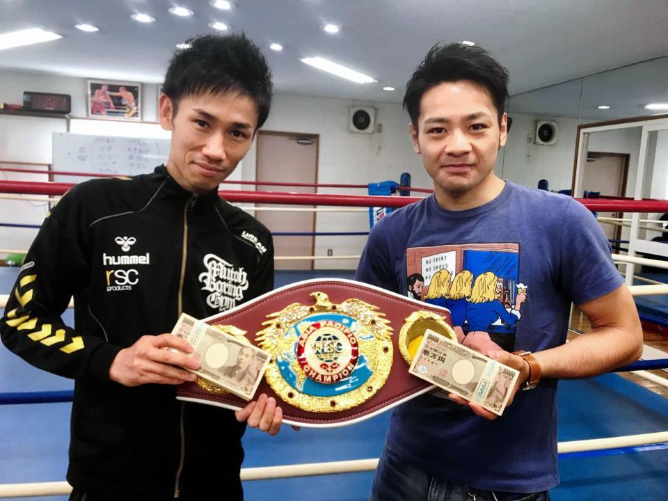 枝川会長から手渡された現金１００万円を手に、笑顔のストロング小林佑樹（右）と武市晃輔トレーナー