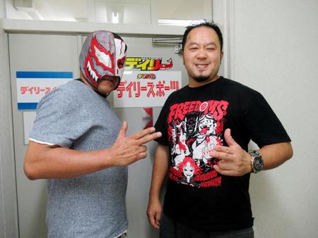 　デイリースポーツ中国本部の前でポーズを決める佐々木（右）とデビルマジシャン