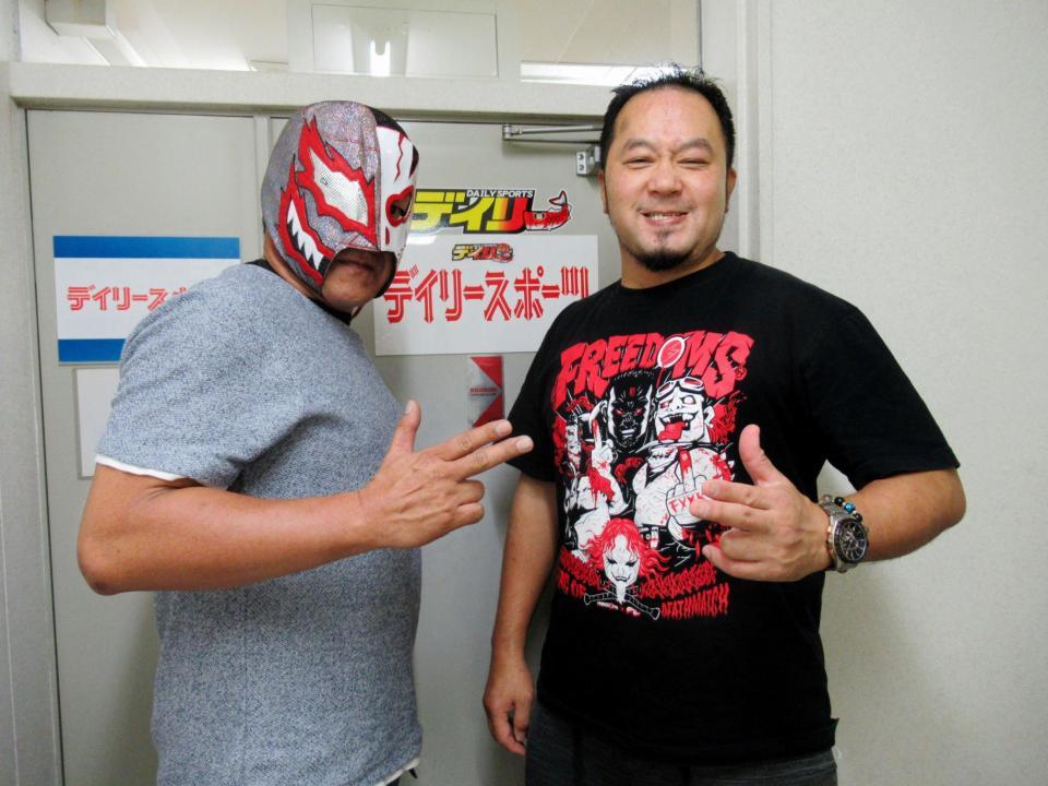 　デイリースポーツ中国本部の前でポーズを決める佐々木（右）とデビルマジシャン