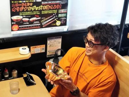 　天下一品から贈られた“金のどんぶり”に驚く京口＝大阪市内の天下一品難波ウインズ前店