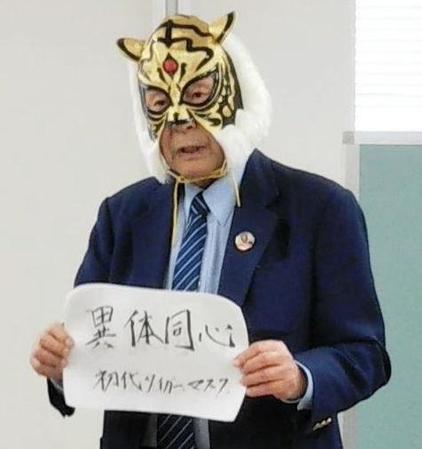 　初代タイガーマスクのメッセージを手にする新間会長