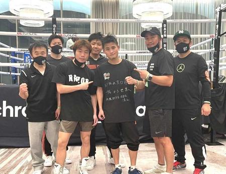 　特設ジムでスタッフに囲まれポーズを取る京口（中央）＝ワタナベジム提供