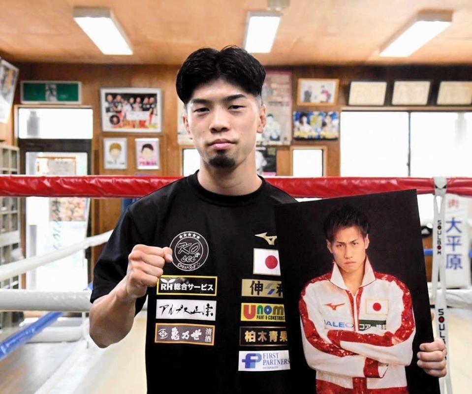 　再起戦の相手・石田匠のパネルを持つ田中恒成（畑中ジム提供）