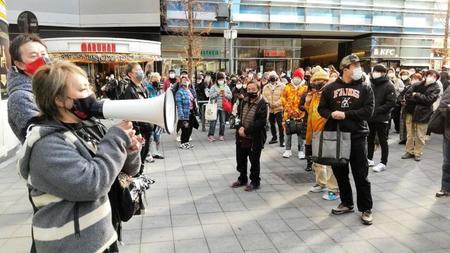 避難した観衆に大会打ち切りを謝罪する社長の尾崎魔弓（左）＝東京・歌舞伎町