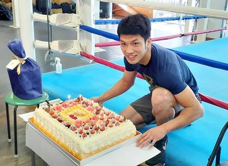 　誕生日ケーキを前に笑顔を見せる村田