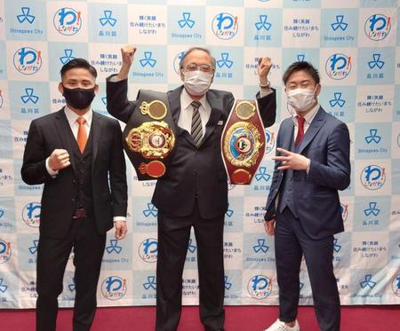 　浜野区長（中）の肩にベルトを掛けてポーズを取る京口（左）と谷口（右）